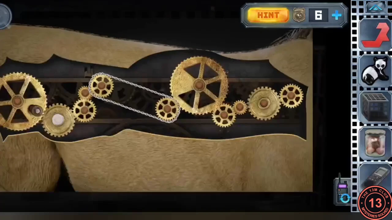 The lion's gear panel with the gears in a continuous train and the bicycle chain looped around the two gears in the middle