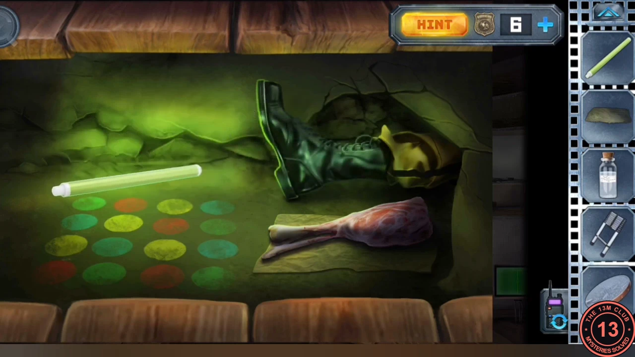 The cabin cellar lit by a green glowstick: a leg in a boot, a raw joint of questionable meat on a cloth, and a four-by-four pattern of coloured circles in green, red, yellow and teal