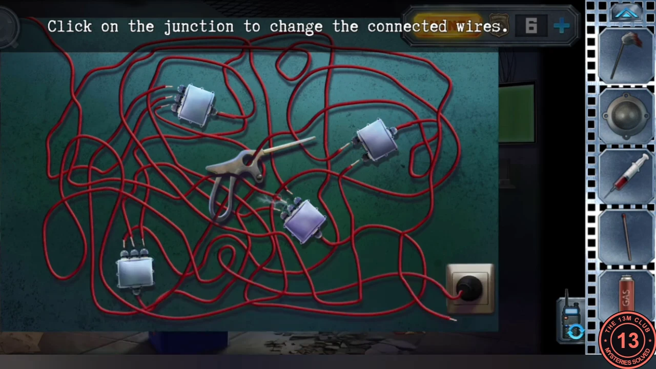 A tangle of red cables under the hospital desk with four junction boxes, a socket at the bottom right and a metal handle lying across the cables, and the instruction to click the junctions to change the connected wires.
