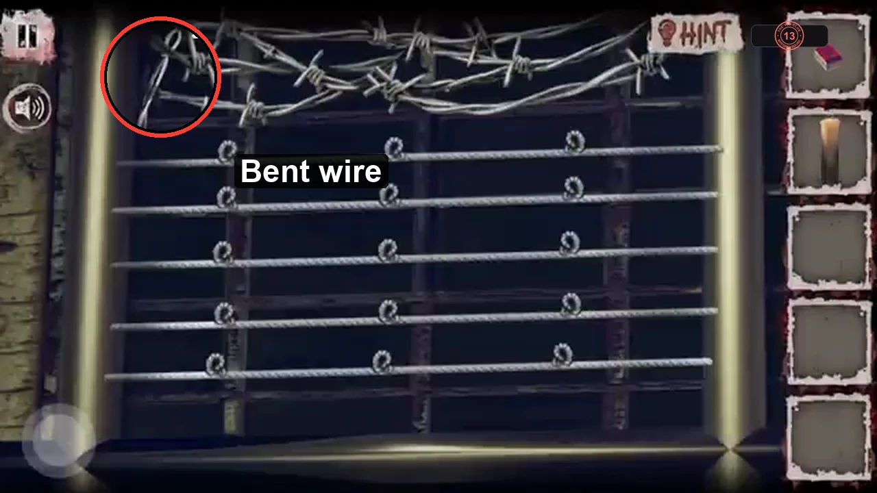 Close-up of the barred window with the loose end of the barbed wire circled at top left
