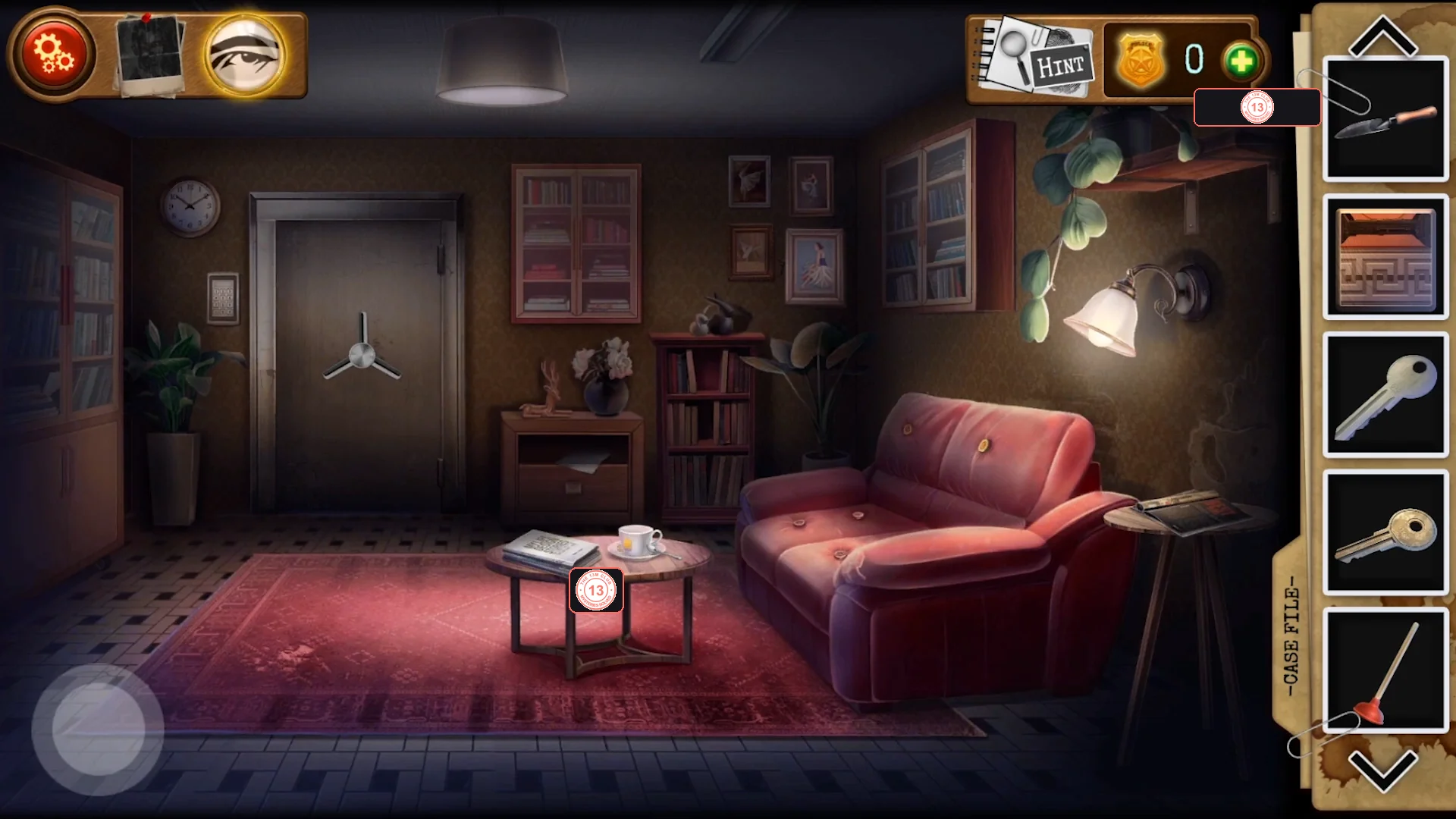 Waiting room with the round vault door on the back wall, a coffee table with a tea set and a pink note, a red sofa, a lamp and a bookcase