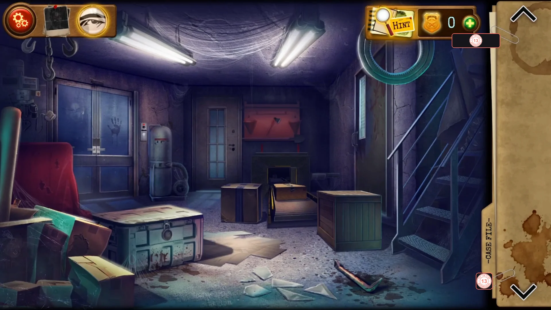 Factory basement with a closed green military chest on the left, two taped cardboard boxes and a wooden crate in the middle, metal stairs on the right and a crowbar lying on the floor in front