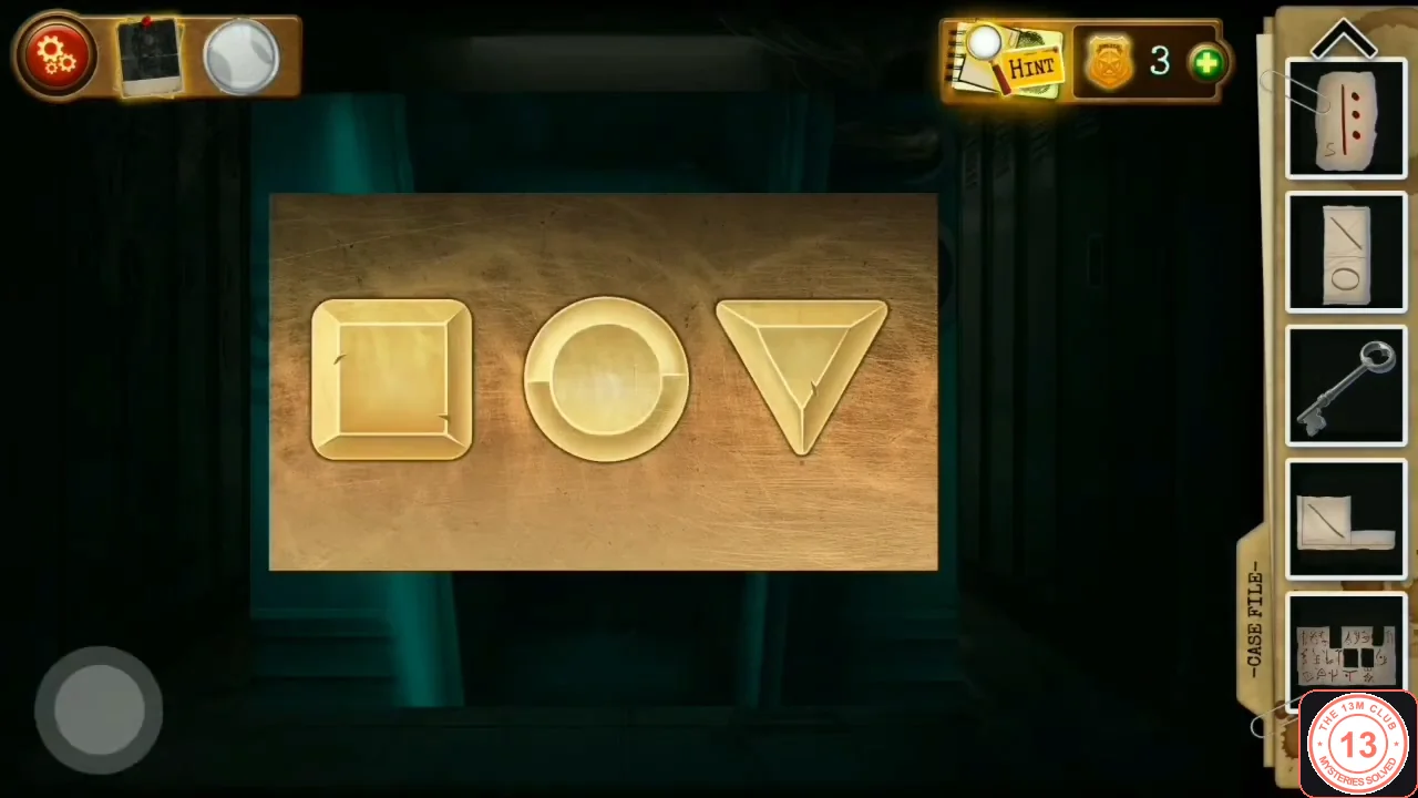 Wooden box lid with three gold buttons: a square, a circle and a triangle