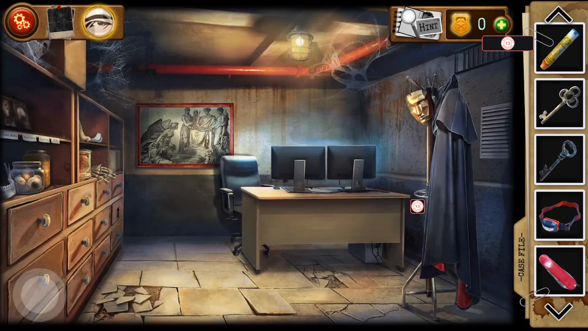 Hidden office with drawers and shelves of jars on the left, a framed picture, a desk with two monitors and a coat stand with a black cloak and mask on the right