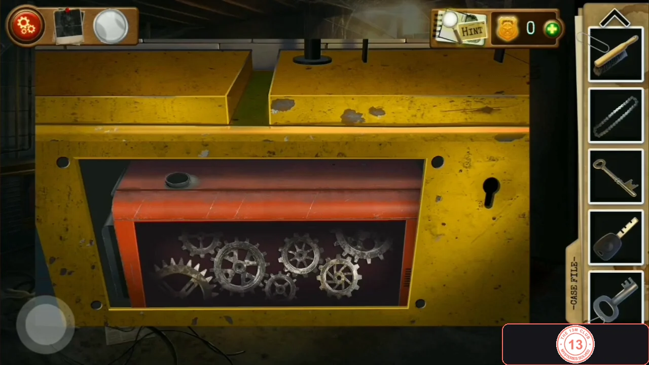 The yellow machine with its cover removed, showing an orange gear compartment with loose gears and a keyhole on the right