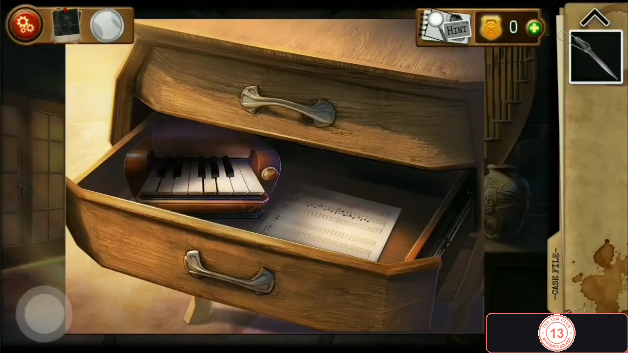 Open top drawer of a chest with a small music-box keyboard and a sheet of music inside