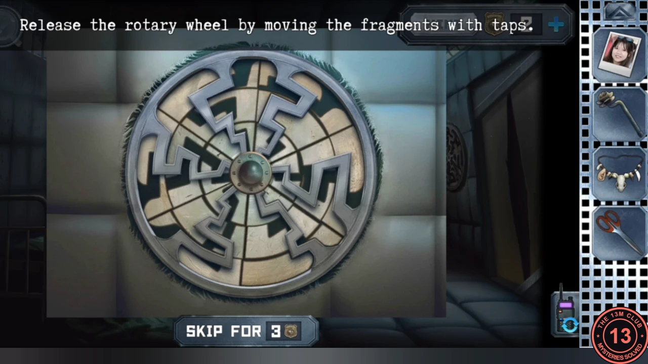 Round rotary wheel behind the padding with scrambled metal zigzag fragments around a central hub, and the instruction to release it by moving fragments with taps