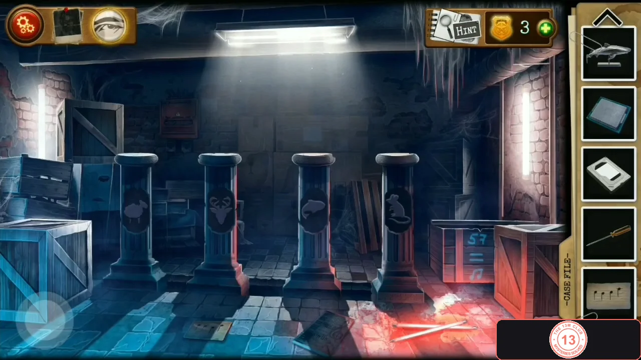 Room with four stone pillars showing animal silhouettes, a blue crate on the left, a red crate and the wall safe at the back and a notebook on the floor