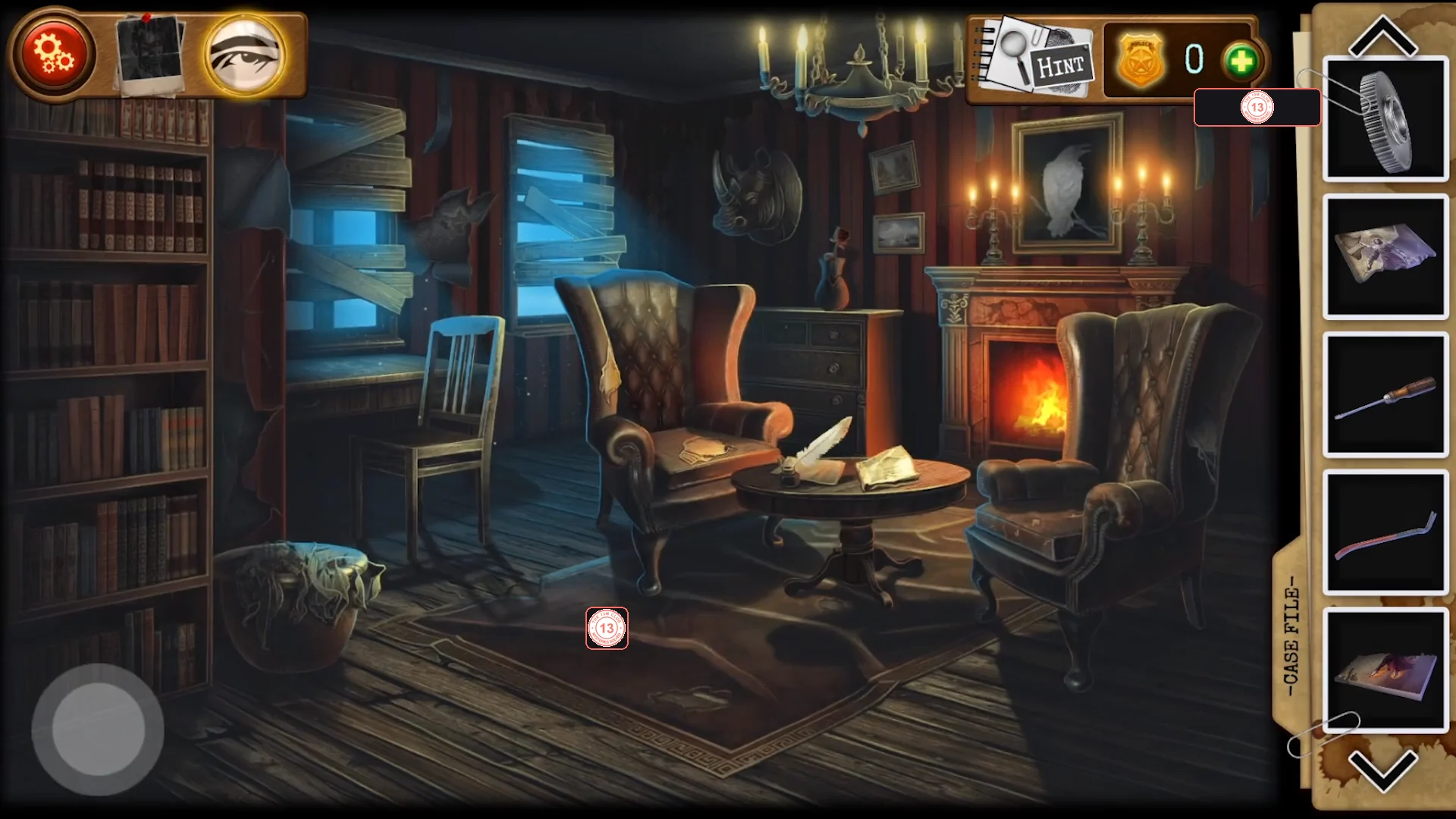 Living room with a tall bookcase on the left, two leather armchairs around a small table on a rug, a burning fireplace and a white-raven painting above it