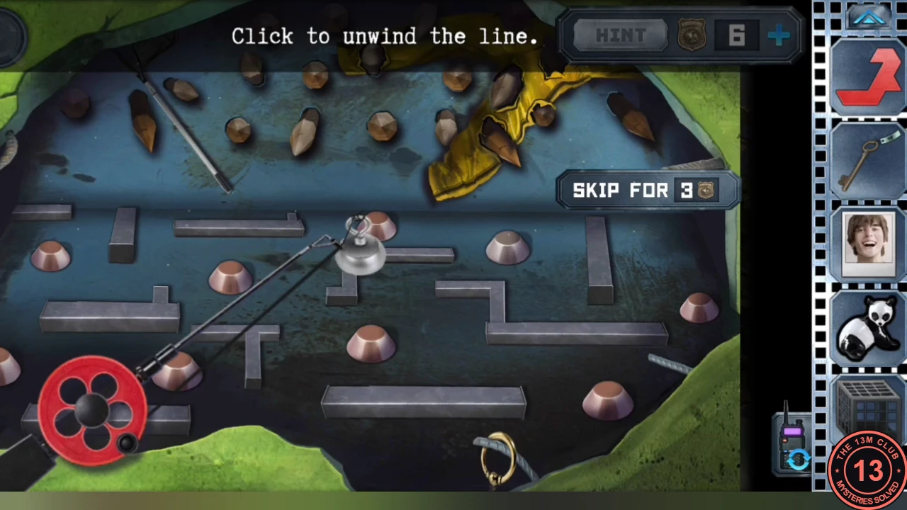 The hole under the tarp seen as a maze of metal walls and copper studs, with the magnet on its line near the top, the red reel bottom left and the round handle ring at the bottom; instruction 'Click to unwind the line'