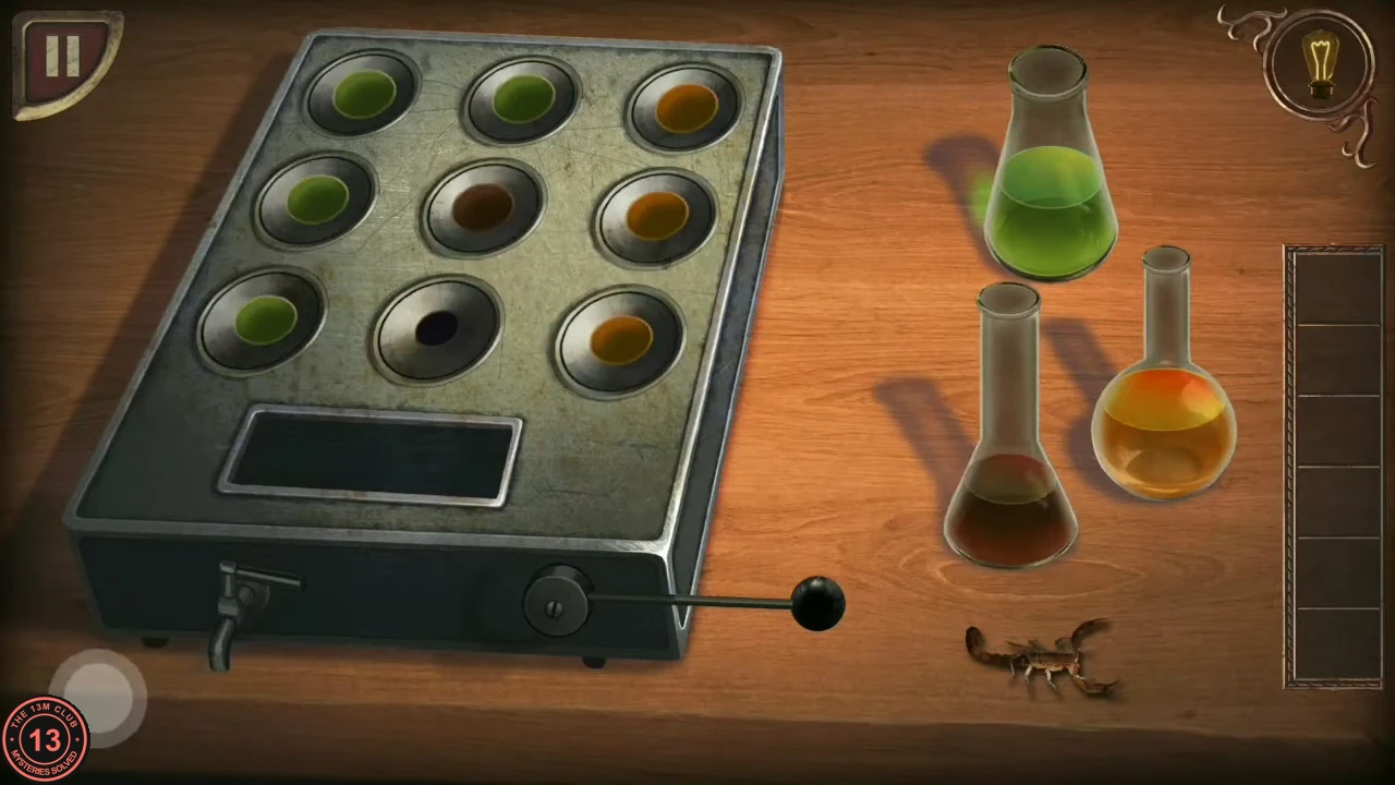 The apparatus with four green, three orange and one brown well filled and one well empty, flasks and the scorpion beside it.
